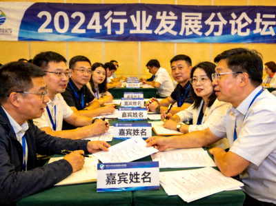 分论坛现场，嘉宾们正在热烈讨论，桌上摆放着名牌和资料