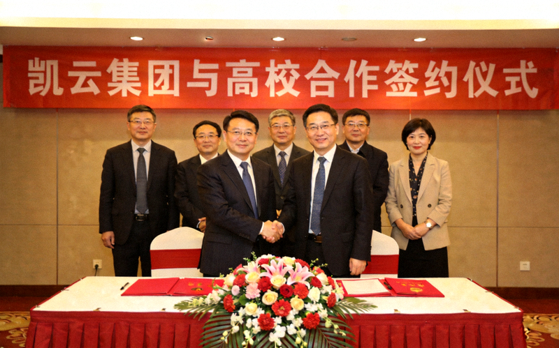 凯云集团代表与多所高校校长在签约仪式上握手合影，背景是合作签约仪式现场